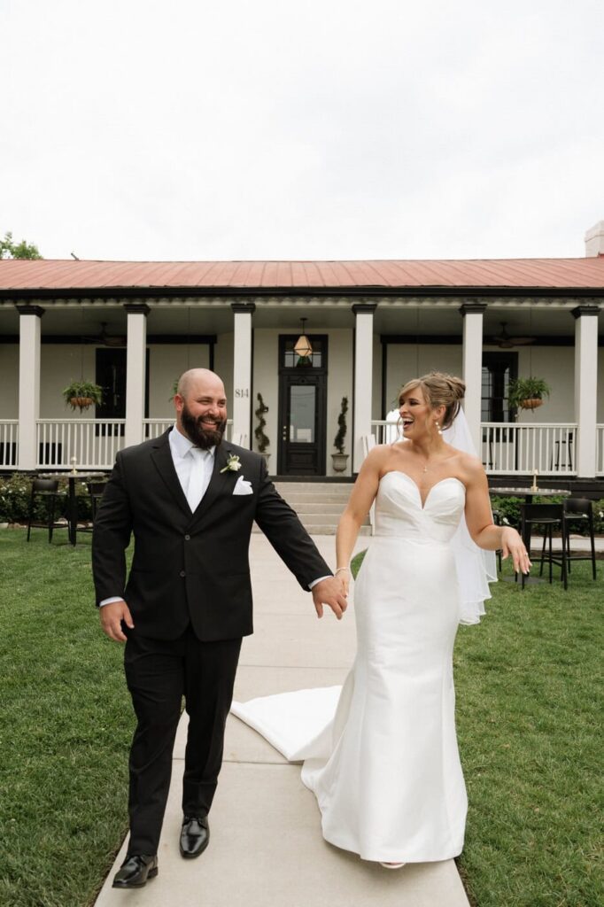 couple laughing while walking at east nashville wedding venue
