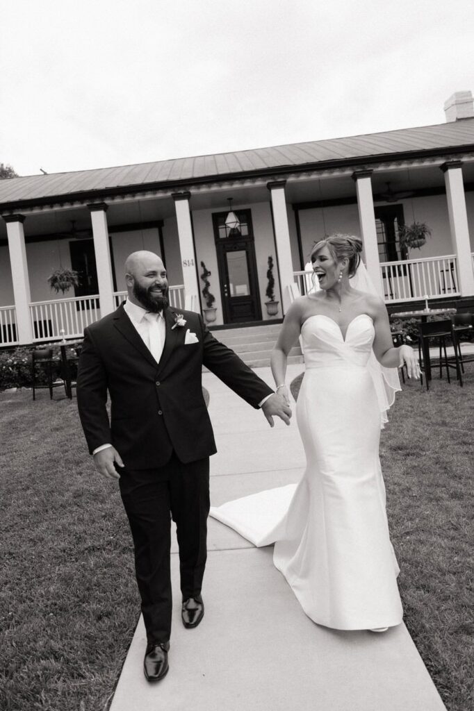 dutch angle of bride and groom laughing while walking outside of the estelle in nashville