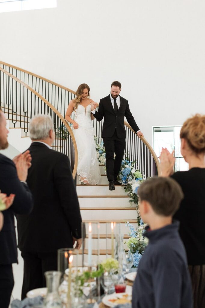 couple entering their reception as guests cheer at the monroe on 415th wedding