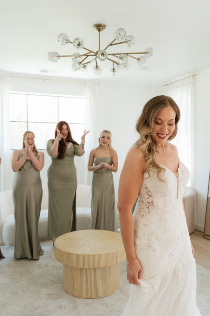 bridesmaids cheering on the bride during their first look