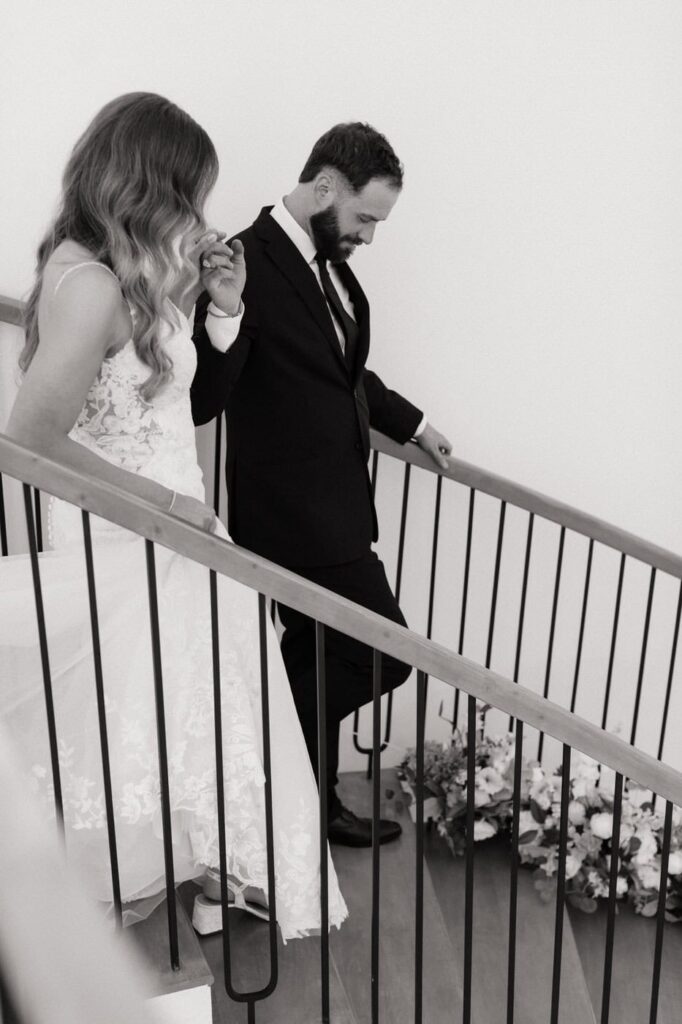 bride and groom walking down the stairs after first look