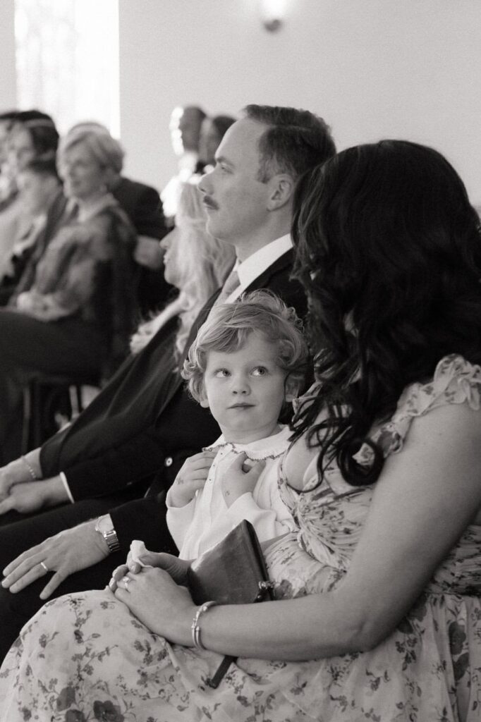 little boy looking up at his mom during wedding ceremony