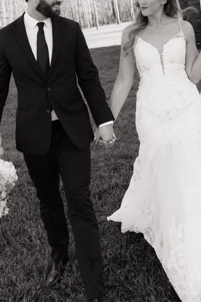 couple holding hands and walking at the monroe on 415th wedding
