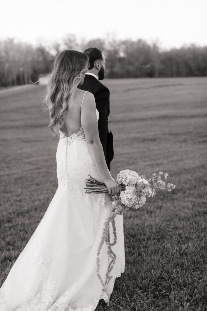 couple holding hands and walking through the fields at the monroe on 415th