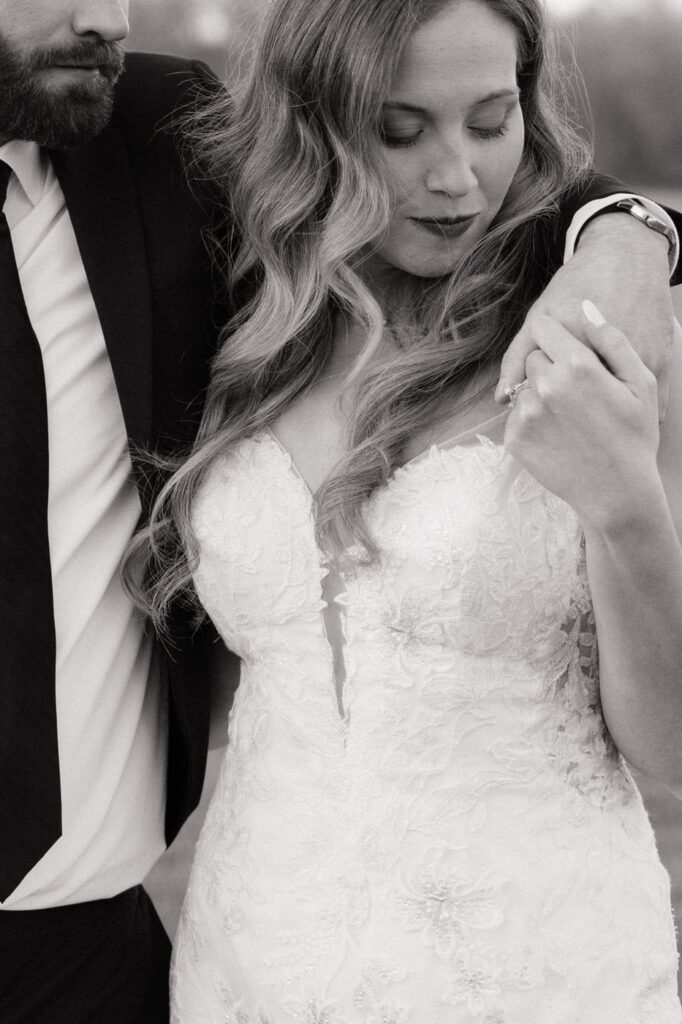 bride looking down at the grooms hand during newlywed portraits