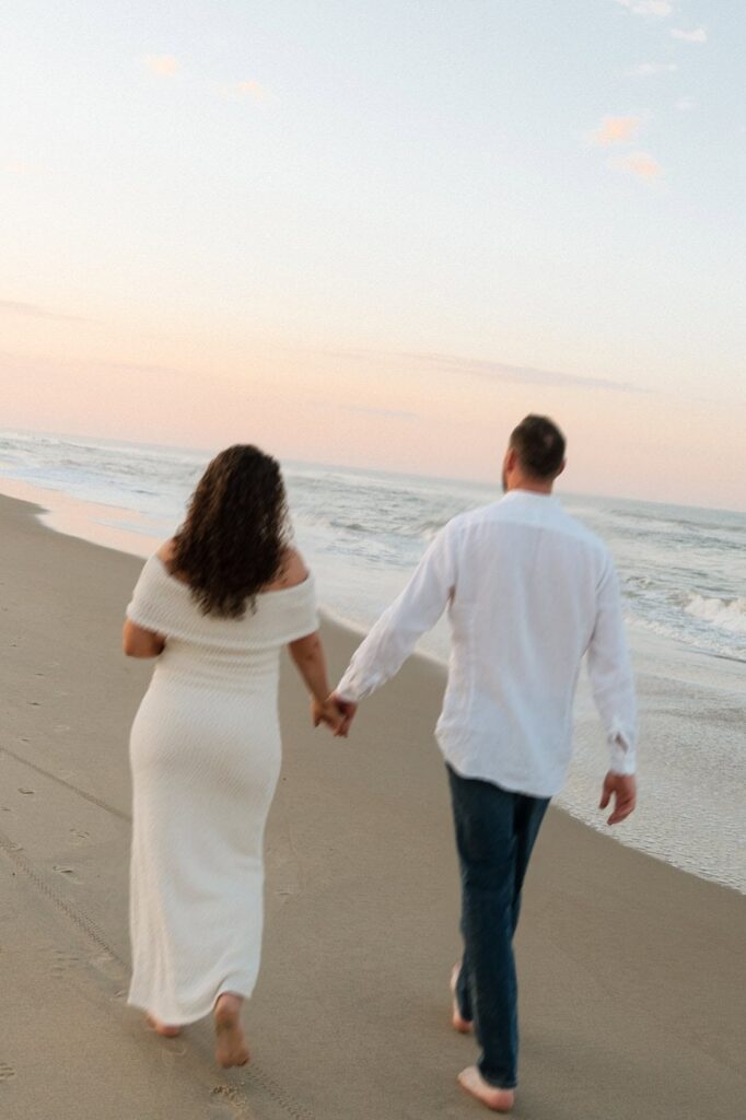motion blur photo of couple holding hands and walking along the beach in virginia beach