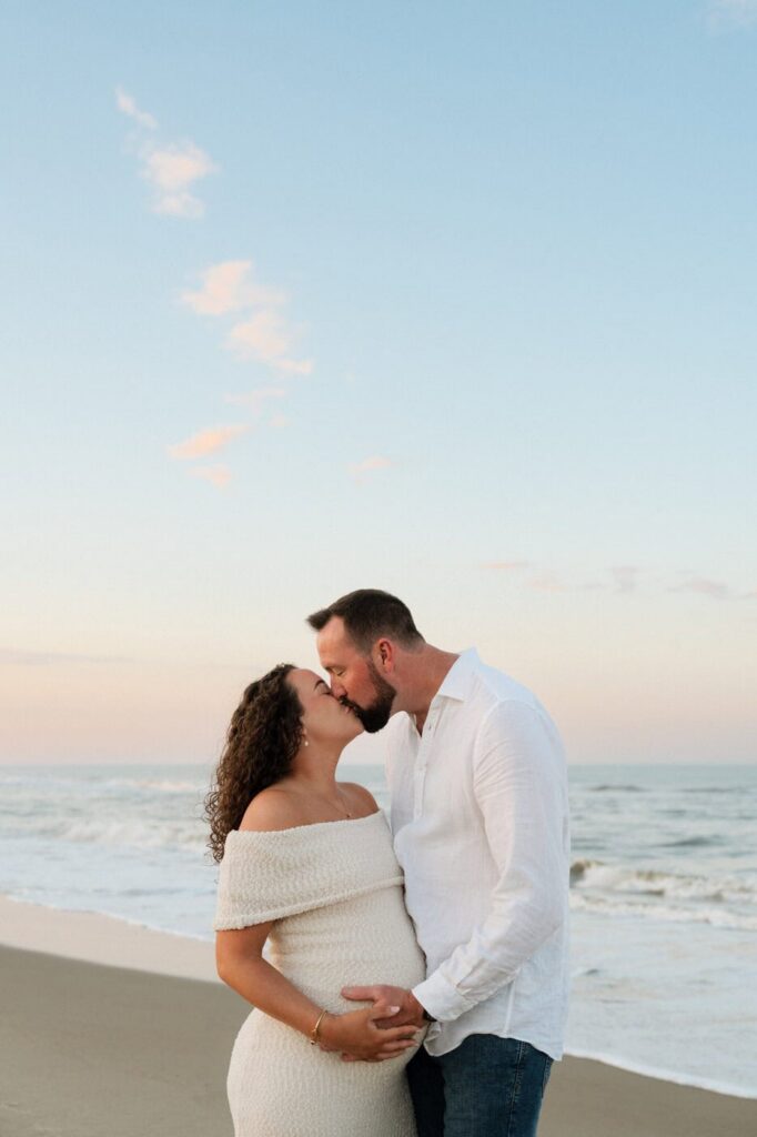 couple kissing during golden hour at back bay maternity session