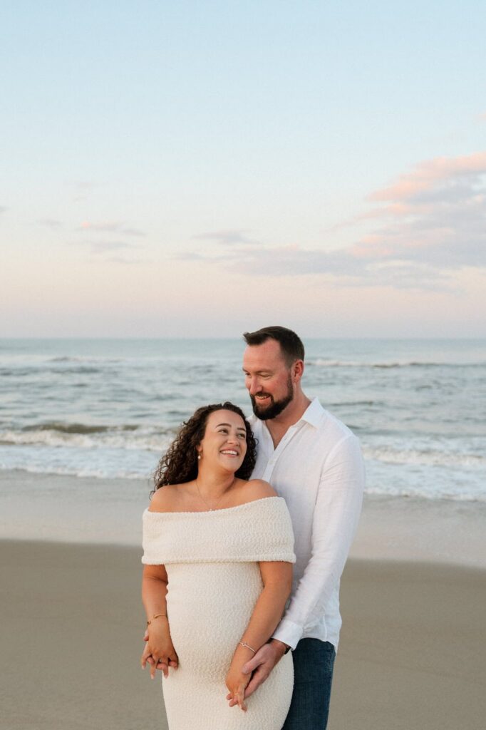 couple laughing during sunset session on the beach