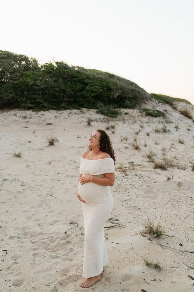 girl holding her pregnant belly and laughing