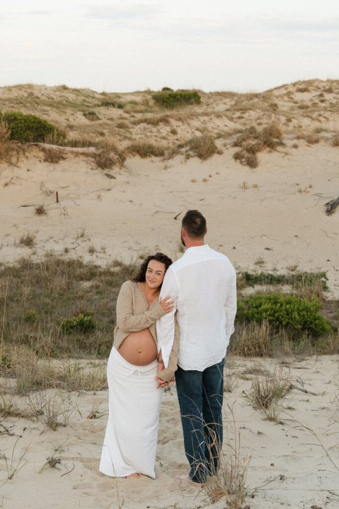 couple holding hands during matnerity session in virginia beach