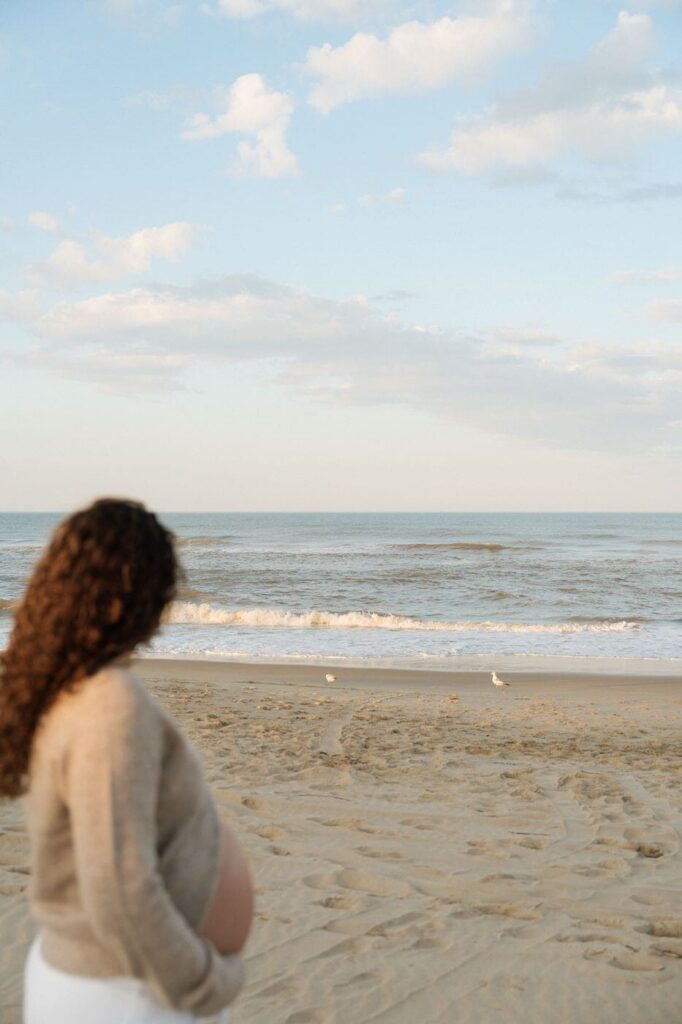 girl looking off at the seagulls on the beach in virginia