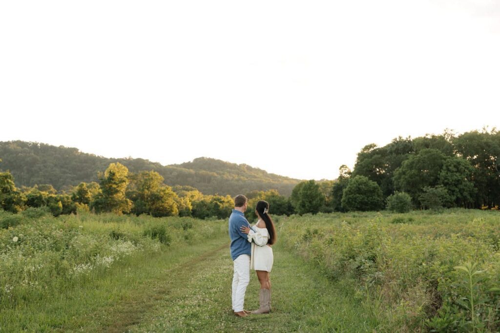couple embracing and watching the sunset at bells bend engagement session in nashville