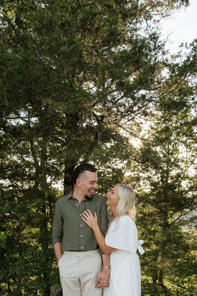 couple holding hands and laughing at spring engagement session at narrows of the harpeth in tennessee