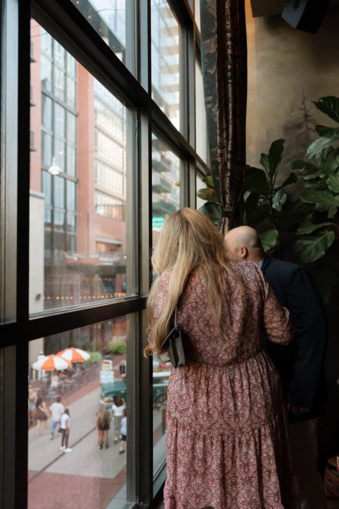 couple looking out the window of the twelve thirty club in downtown nashville